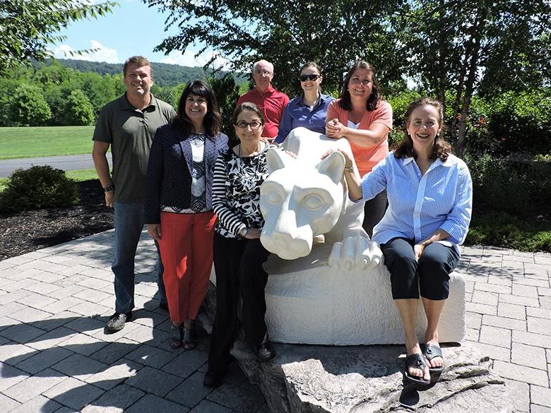 faculty and 工作人员 members posing with the nittany lion shrine